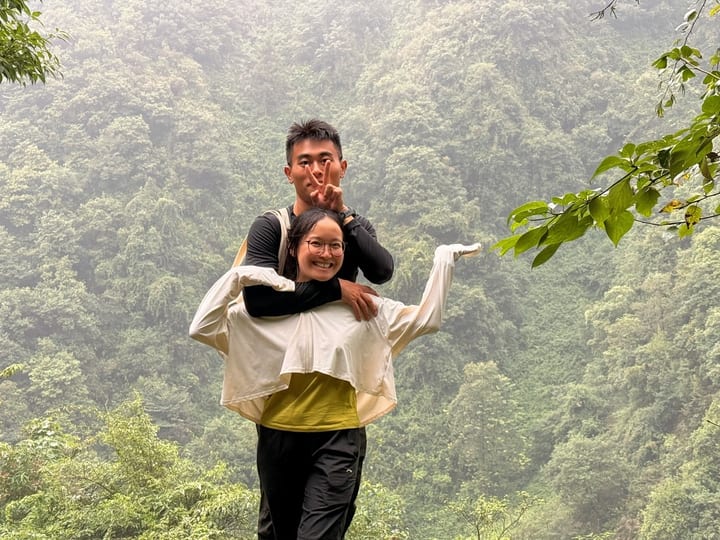 一人背起另一人望向森林山谷