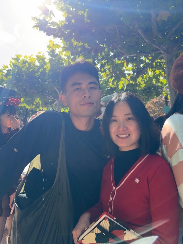 两人在树影下微笑合影