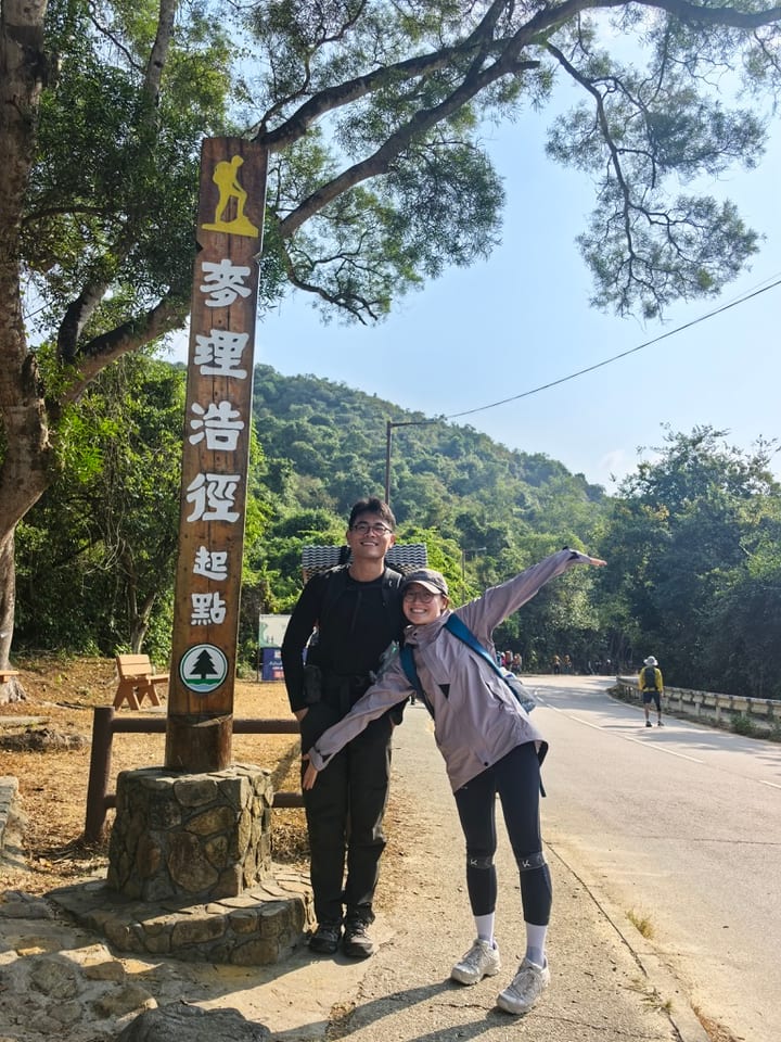两人在林间指示牌旁合影