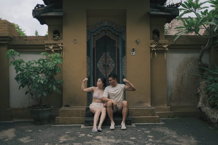 两人坐在雕花木门前举起手臂