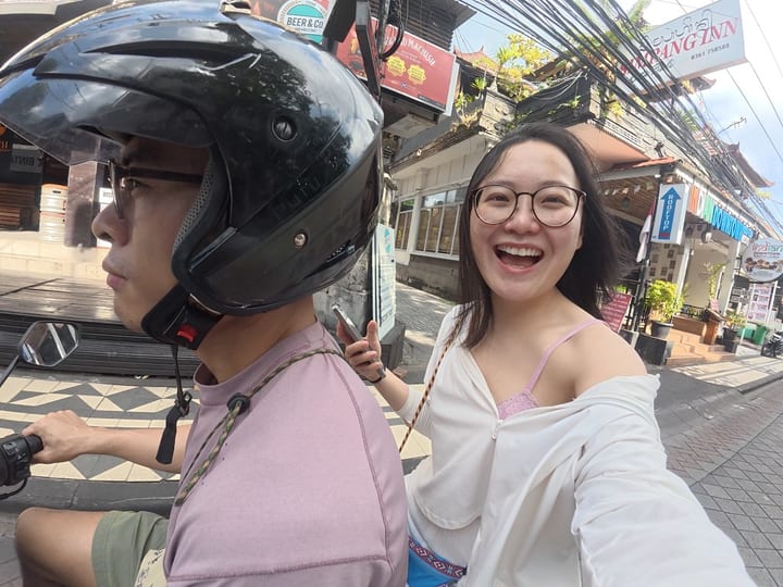 骑行者戴着头盔，同伴在身后微笑