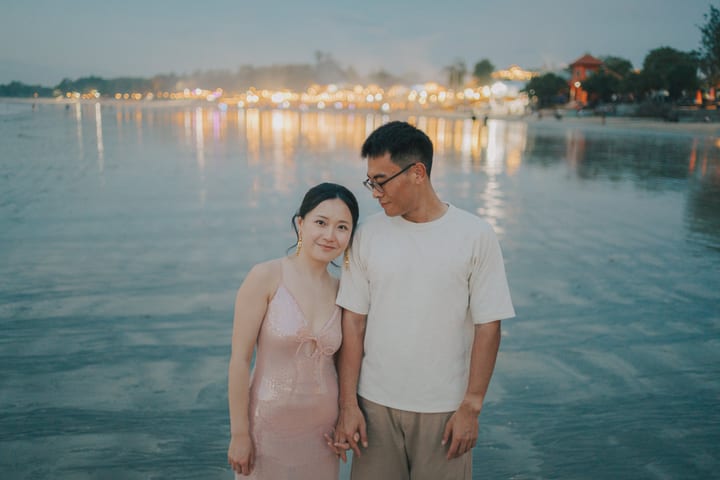 两人在傍晚海边牵手依偎
