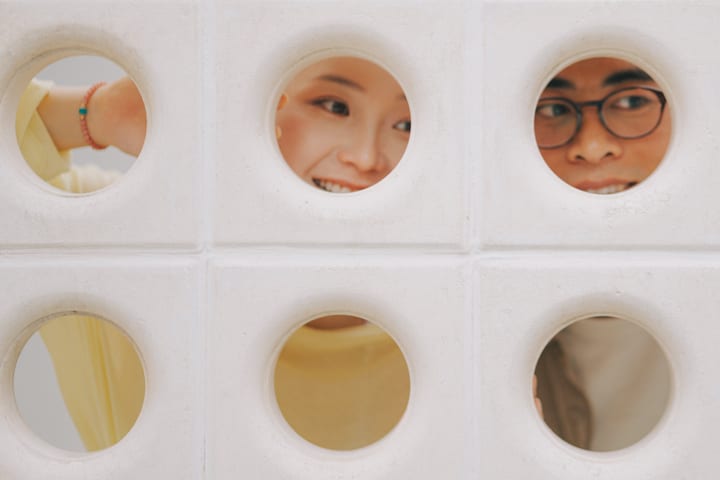 两人从圆形窗格中露出眼睛