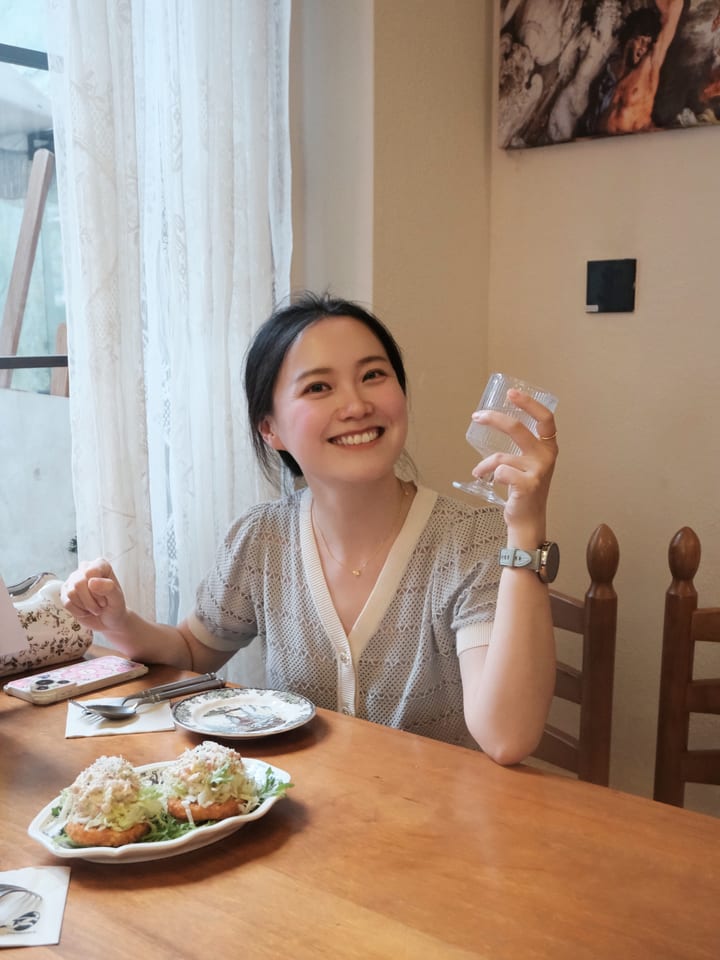 一人在餐桌前举杯微笑