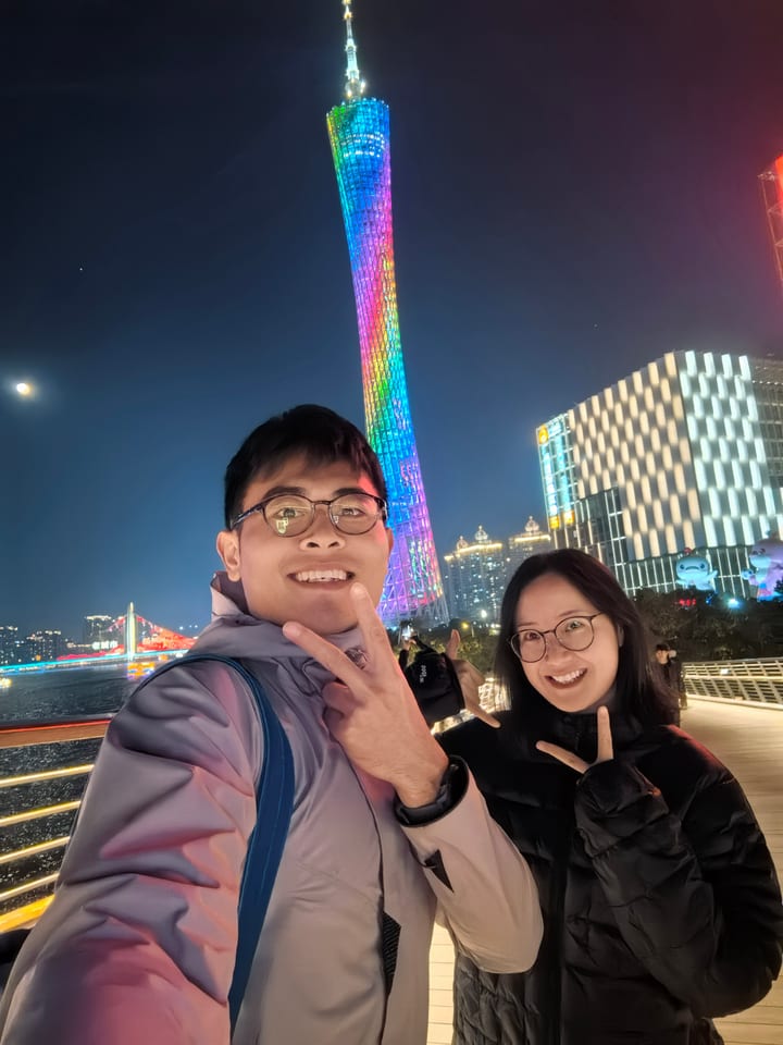 两人在夜晚彩色灯光前自拍