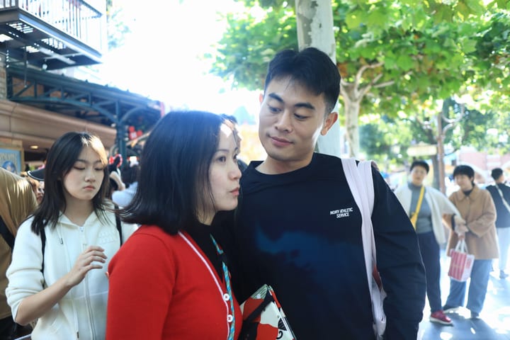 两人穿着红黑上衣在街边相望